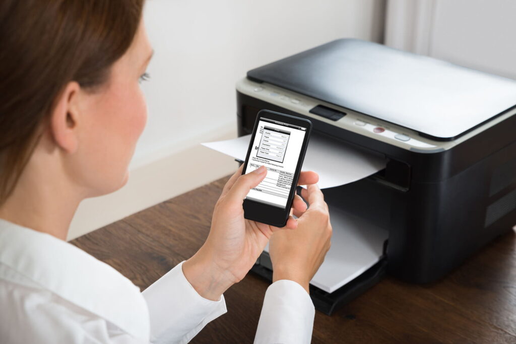 A woman sending a print job from your smartphone to a printer