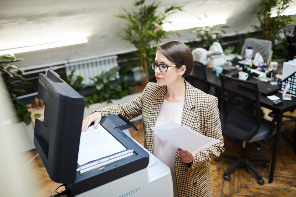 Imagen de una mujer haciendo a digitalización de un documento en una impresora