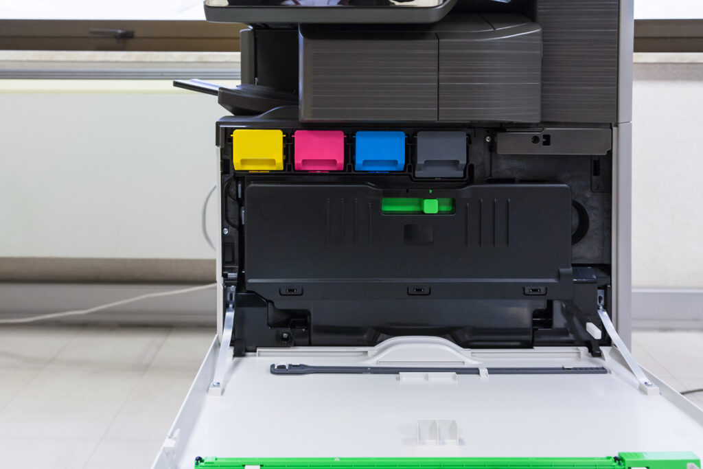 Copier with four toner cartridges with open cover in office hall