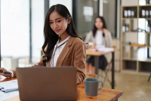 Mulher numa mesa corporativa trabalhando em um notebook