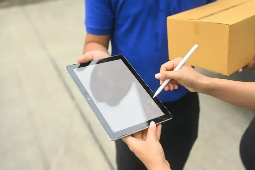 um homem apresentando o recibo de entrega de mercadoria num tablet.